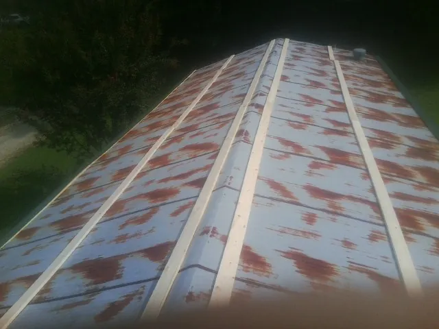 Rusted metal roof panels with new wood purlins before replacement — Storm Damage Roof Repair in Laurel Hill by Roofing Brothers